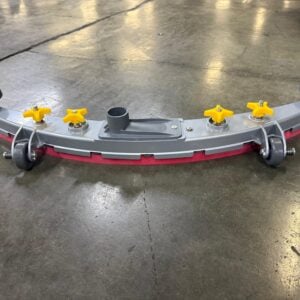 A complete curved floor scrubber squeegee assembly resting upright on a concrete floor, featuring four yellow adjustment knobs, central suction port, guide wheels, and bumper wheels.